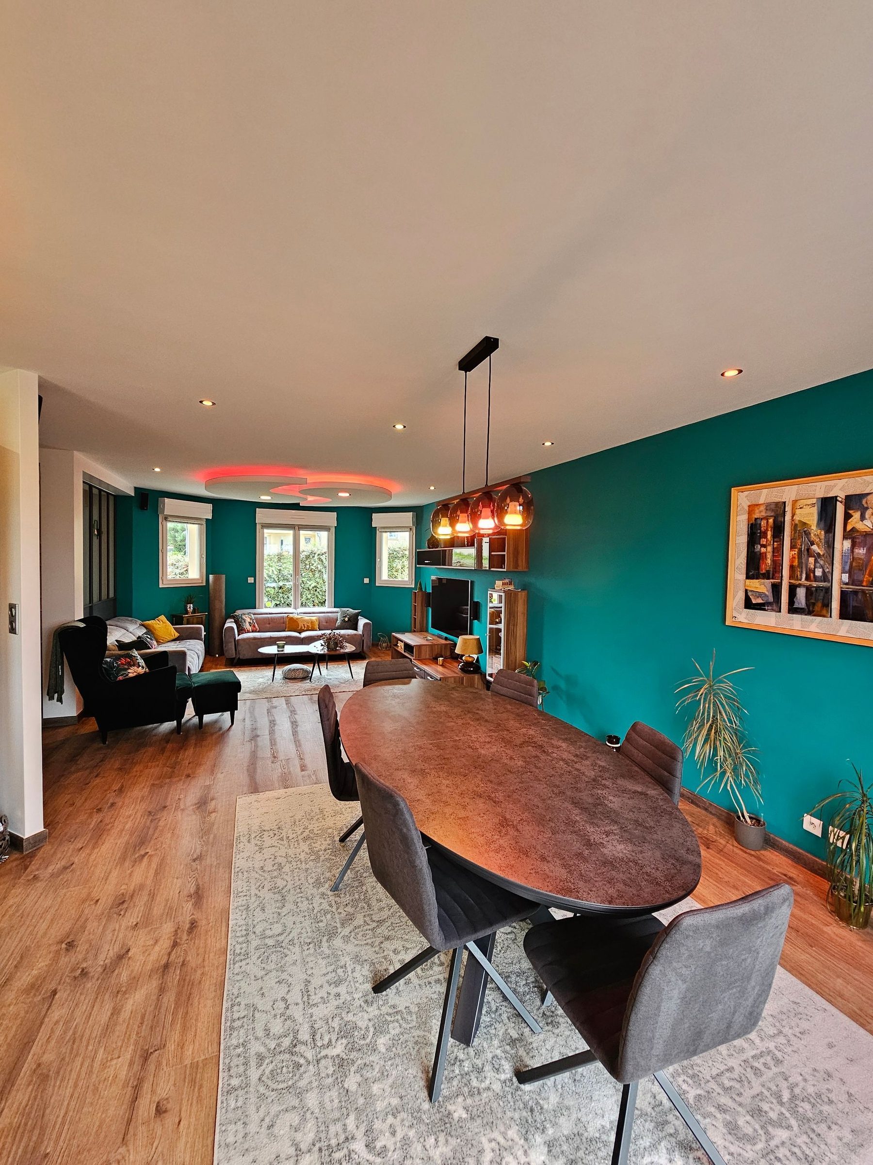 Séjour aux murs bleu canard avec faux plafond arrondi rétroéclairé